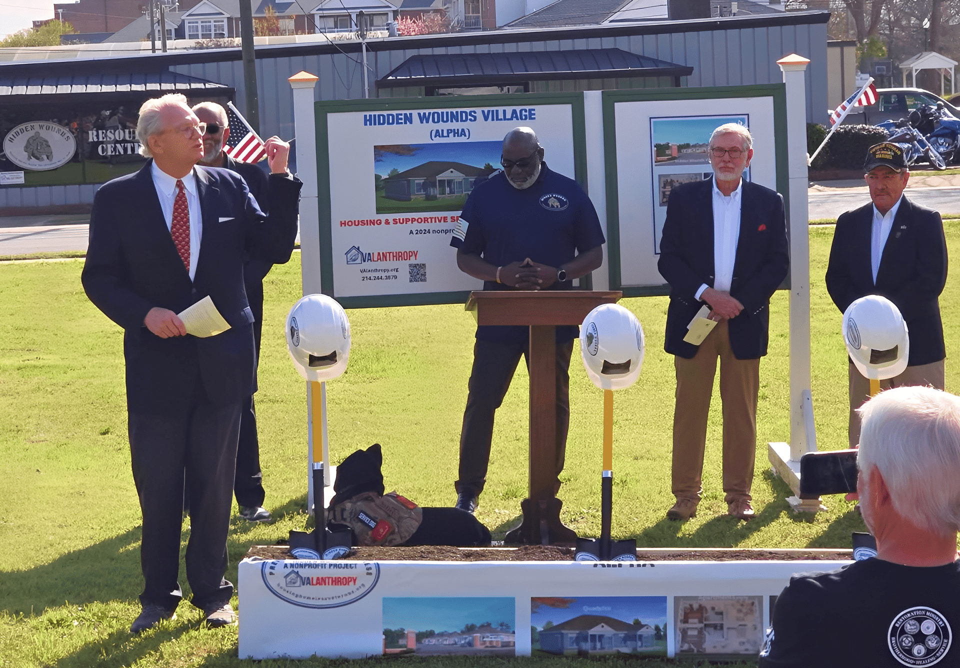 Formal gathering with construction helmets displayed
