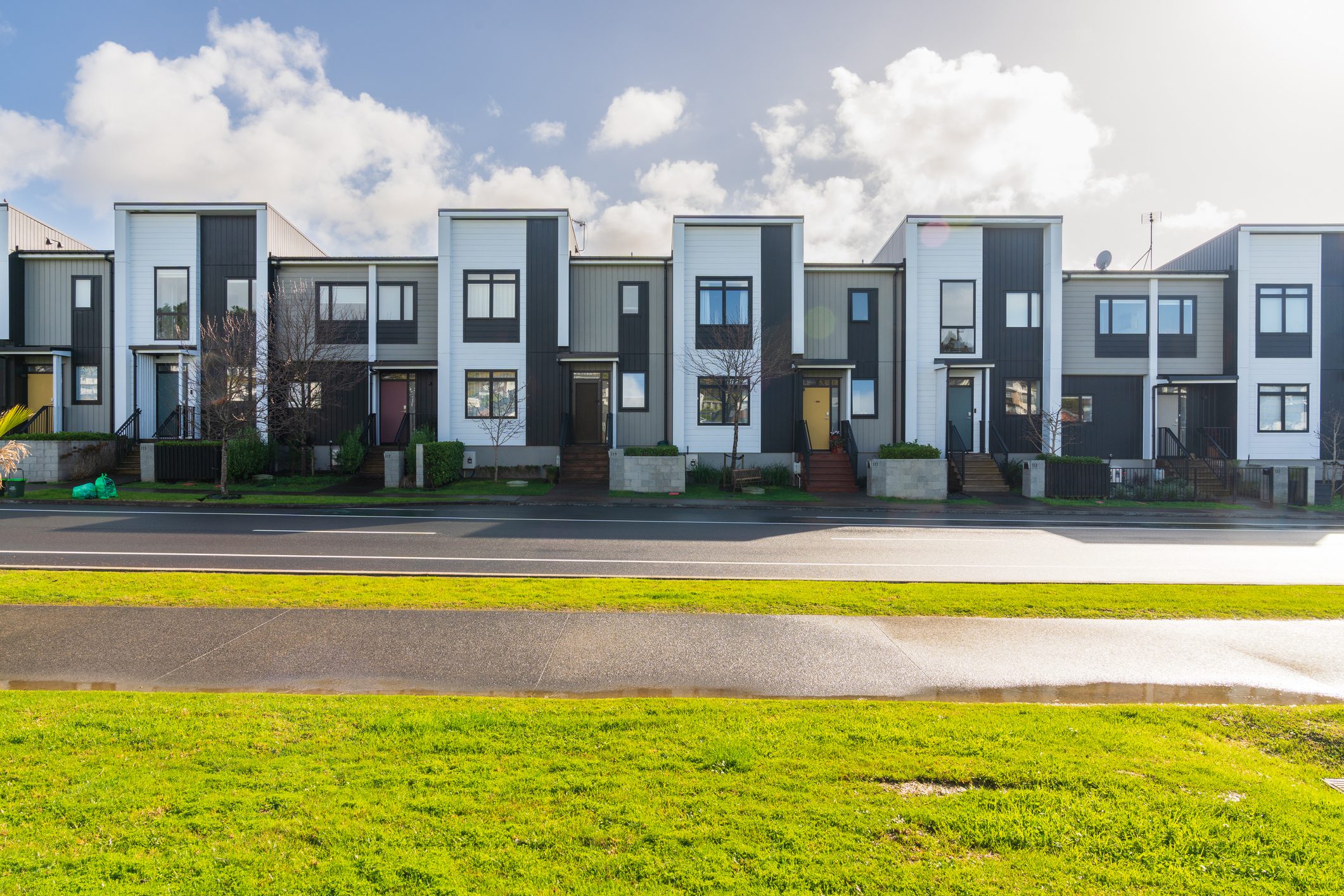 Modern row of townhouses with green lawn