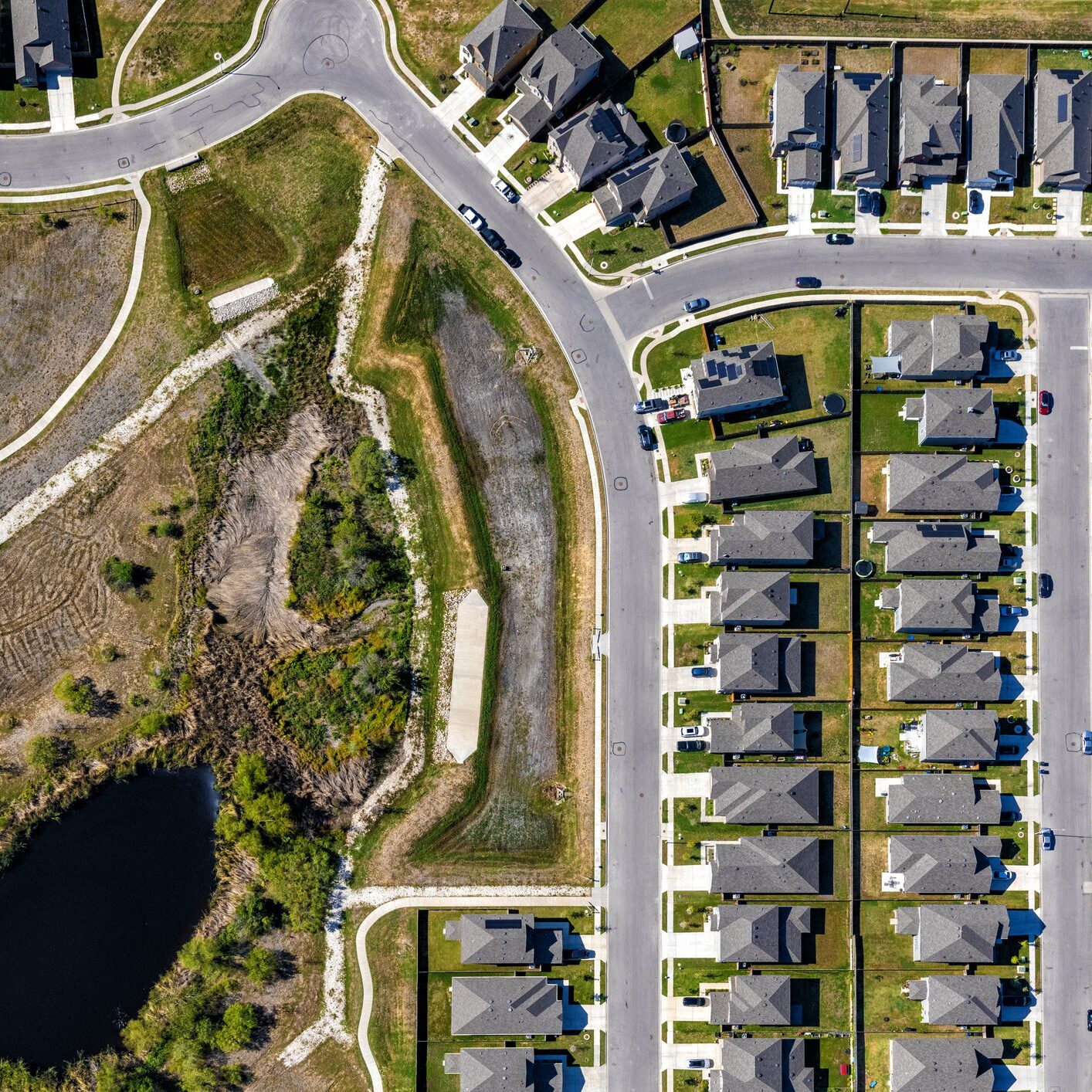 Aerial view of suburban houses and pond
